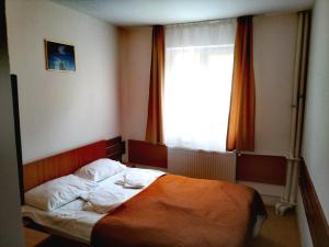 a bedroom with a bed with an orange blanket and a window at HOSTEL CPPI Nord in Buşteni