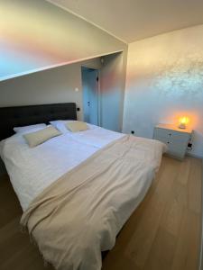 a bedroom with a large white bed with a night stand at Vanalinna apartment in Haapsalu
