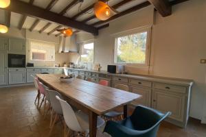 cocina con mesa de madera y sillas en La Villa Dorange, EXCEPTIONNELLE et SPACIEUSE, en Sailly-Flibeaucourt