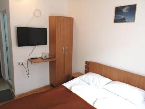 ブシュテニにあるHOSTEL CPPI Nordのベッドと壁にテレビがある寝室