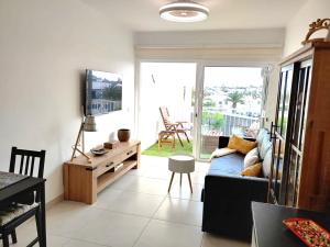 un soggiorno con divano, TV e tavolo di Apartment Aqui Todo Empieza - Pool view - Free WiFi - smart TV-Residence Senator a Costa Teguise