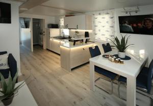 a kitchen and living room with a white table and chairs at Floating house Maui in Portorož