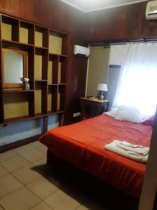 um quarto com uma cama com uma colcha vermelha em Hotel Duclout Confort Inn em Monte Grande