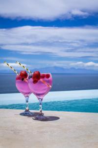 a pink drink with two cherries in a glass at Aqua Terra Boutique Guesthouse - Simon's Town, Cape Town in Simonʼs Town