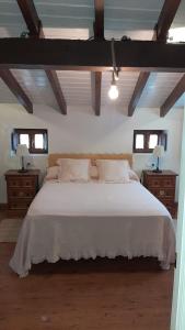 a bedroom with a white bed with two dressers and two windows at El Cantón de Poo, agradable casa adosada a 800m de la playa VV-2256-AS in Llanes +46 photos