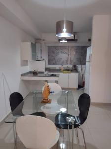 a glass table and chairs in a small kitchen at Departamento 1 dormitorio, Saenz Peña. in Santiago del Estero