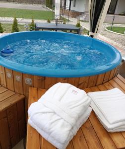 a hot tub with a towel on a wooden deck at Pensiunea ARC Bucovina in Vama