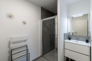 a bathroom with a shower and a sink and a mirror at L'eclat de Stagnola in Pietrosella