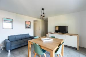 a living room with a table and a couch at L'eclat de Stagnola in Pietrosella