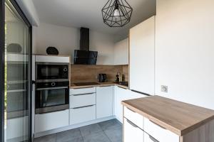a kitchen with white cabinets and a wooden counter top at L'eclat de Stagnola in Pietrosella
