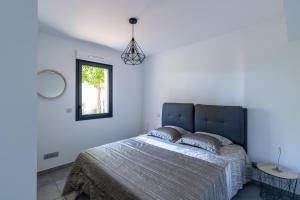 a bedroom with a large bed and a window at L'eclat de Stagnola in Pietrosella