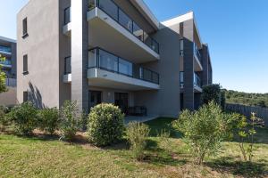 an apartment building with bushes in front of it at L'eclat de Stagnola in Pietrosella