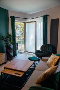 a living room with a couch and a coffee table at APARTAMENT ELEGANCE GREEN w Let's Sea Basen&SPA in Gąski +41 photos