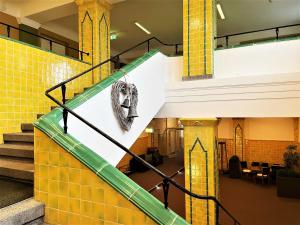 un escalier dans un bâtiment avec un masque sur le mur dans l'établissement IBS Begegnungszentrum, à Laubusch