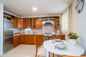 a kitchen with a white table and a refrigerator at Apartment Mioć in Dubrovnik
