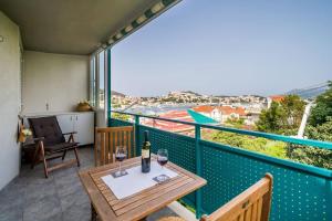 a balcony with a table and two glasses of wine at Apartment Mioć in Dubrovnik