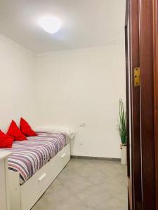 um quarto com uma cama com almofadas vermelhas em La Primera de Occidente em Cádiz