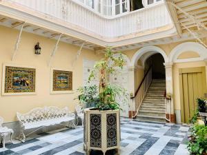 um edifício com uma escada e um quarto com um vaso de plantas em La Primera de Occidente em Cádiz