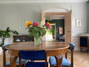 wazon kwiatów na drewnianym stole w pokoju w obiekcie Dom Pułkownika w Kłodzku