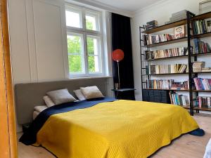 a bedroom with a bed with a yellow blanket at Dom Pułkownika in Kłodzko