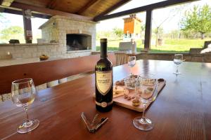 a bottle of wine sitting on a table with two glasses at Robinson House Istra Vižinada Poreč in Vižinada