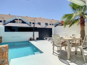 a patio with a table and chairs next to a pool at Ribera Nature Villa - 7209 in Santiago de la Ribera