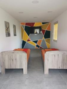 Habitación con 2 bancos de madera y un mural en Podlovics Tanya Panzió, en Kemecse