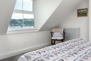a bedroom with a bed and a chair and a window at Haulfryn Apartment in Conwy