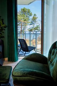 a living room with a couch and a large window at APARTAMENT ELEGANCE GREEN w Let's Sea in Gąski
