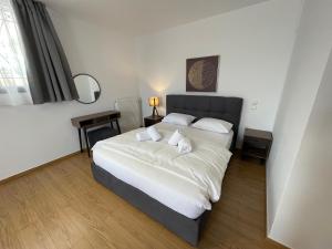 ein Schlafzimmer mit einem großen Bett mit weißer Bettwäsche und Kissen in der Unterkunft Nala's Apartment II in Nafplio
