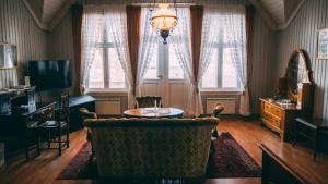 a living room with a chair and a table and windows at Negarden 1897 in Åsnes