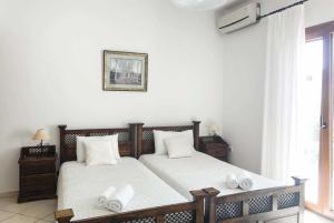スコペロスにあるVilla Maroのベッドルーム1室(ベッド2台、白いシーツ、タオル付)