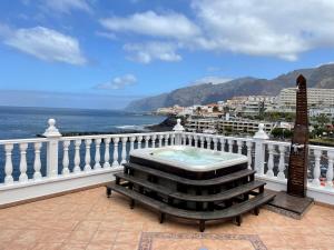 balcón con mesa y vistas al océano en Luxury Villa Los Gigantes, en Puerto de Santiago