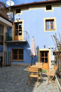 a patio with a table and chairs in front of a house at Dal Ciavatin in Paesana