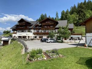 a large building with cars parked in a parking lot at Hotel Schröckerhof in Schladming