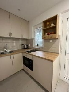 a kitchen with white cabinets and a wooden counter top at Dolce Casa in Kotor