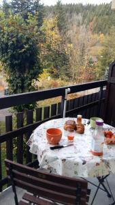 einen Tisch mit Speisen und Getränken auf dem Balkon in der Unterkunft Le Chartreux de Saint Pierre de Chartreuse in Saint-Pierre-de-Chartreuse