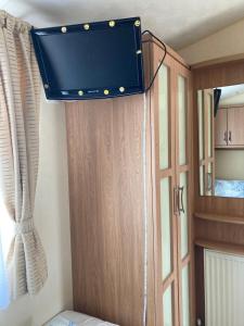 a tv hanging from the ceiling of a room at Caravan Skegness GB 148 in Chapel Saint Leonards