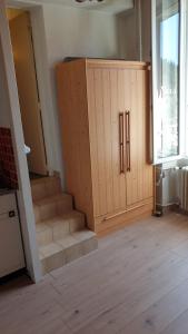 a room with a wooden cabinet with stairs in it at Joli Studio Chamechaude in Saint-Pierre-de-Chartreuse