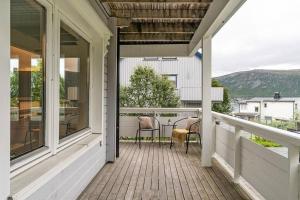 un porche con 2 sillas y una mesa en Arctic 3 room apartment - Aurora View - Free Parking, en Tromsø