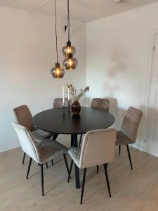 a dining room table with chairs and a black table with candles at Arctic 3 room apartment - Aurora View - Free Parking in Tromsø