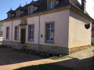 ein rosafarbenes Haus mit schwarzem Dach in der Unterkunft Gite de Belle vue in Semur-en-Brionnais