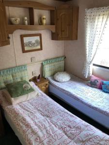 Kruszyny SzlacheckieにあるLeśna cisza w Ładnówkuのベッド2台と窓が備わる小さな客室です。