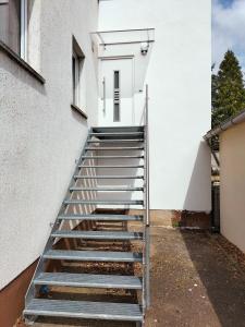 a stairway leading up to a white building at Ferienwohnung Kreuzgasse in Bad Frankenhausen