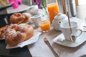 een ontbijttafel met zoete deegwaren en een kopje jus d'orange bij Il Fiore in una Stanza in Itri