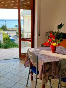 una mesa con un jarrón de flores encima en A Levante en Ascea