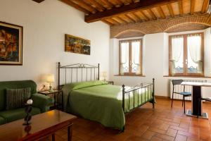 een slaapkamer met een bed, een bank en een tafel bij Casa Aurora in Massa Marittima