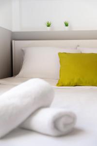 un letto bianco con un cuscino giallo di HOTEL_TIER ad Atene