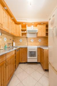 a kitchen with wooden cabinets and a white refrigerator at 101 Apartman Agárd,Török Bálint utca 101 in Agárd