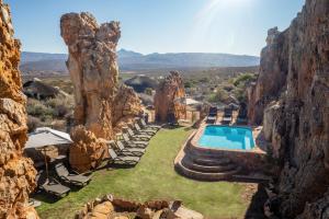 a resort with a pool and chairs and a rock wall at Kagga Kamma Nature Reserve in Lochlynne